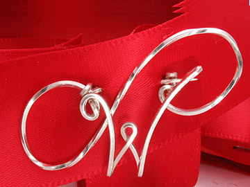 Initial Pin with twisted 'S' behind.